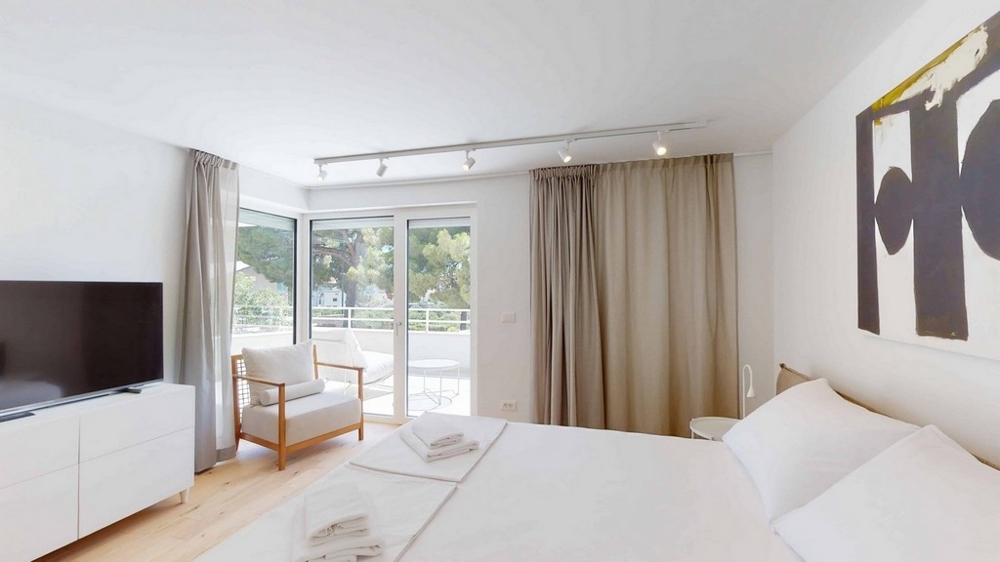 Utsikt över husets baksida med ytterligare parkeringsplatser och utsikt över havet - köp en lägenhet i Kroatien.