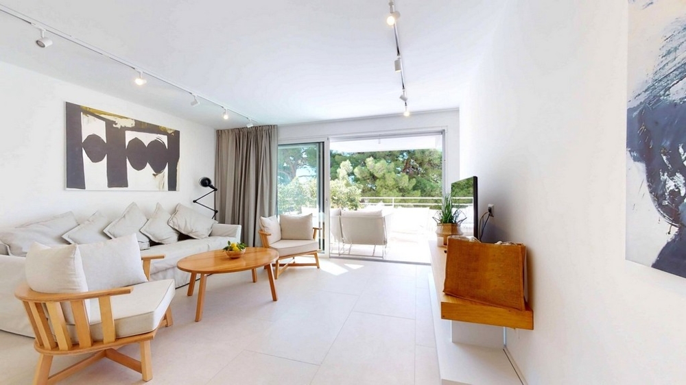 Lägenhet i skalet med utsikt från vardagsrummet med stort fönster och utgång till balkongen.