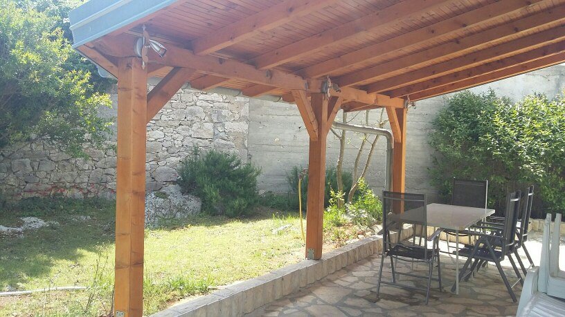 Trädgård och täckt terrass.