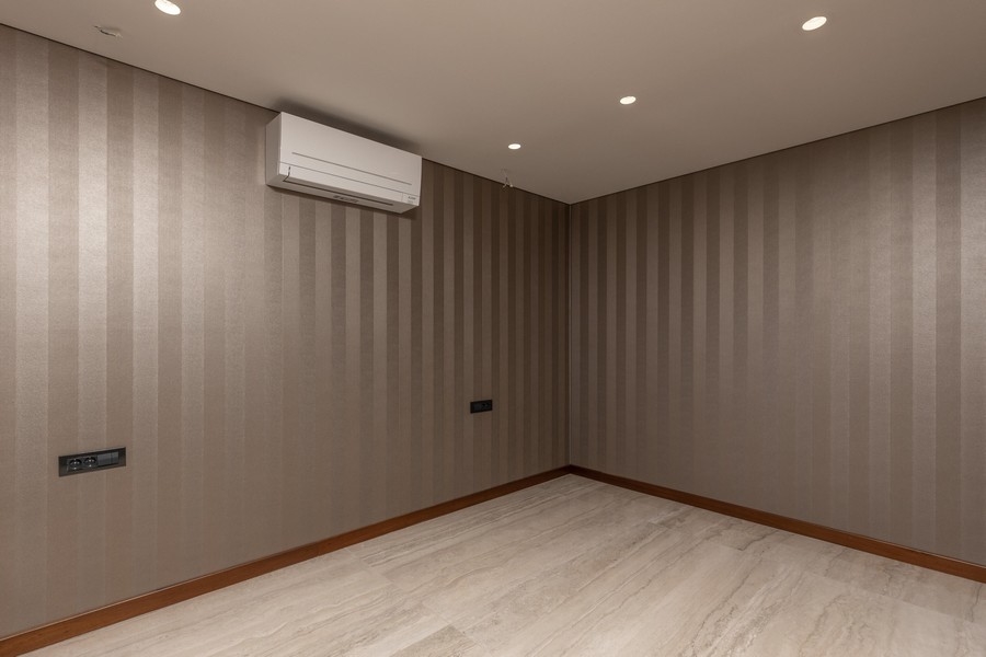 Sovrum med högkvalitativ tapet och luftkonditionering.