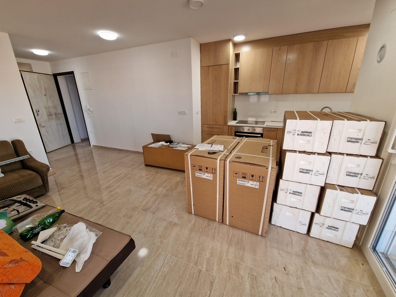 Modernt vardagsrum med öppet koncept och kök.