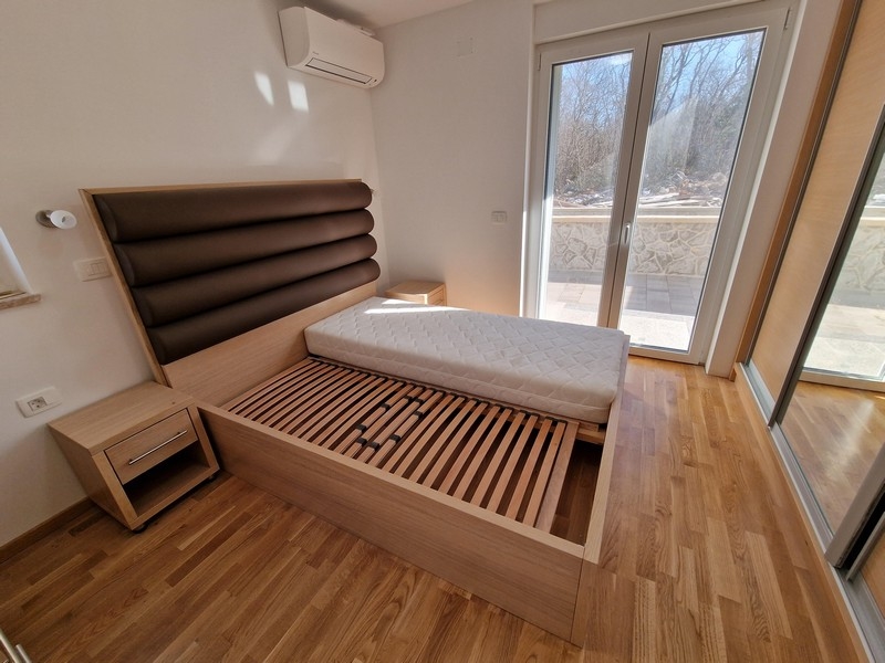 Dubbelsäng i sovrummet och utsikt över terrassen.