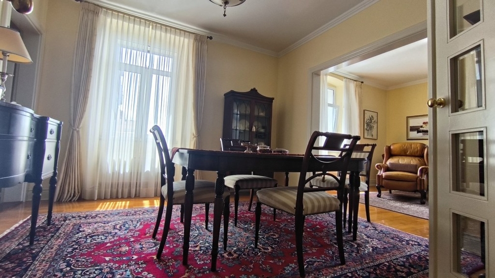 Vardagsrum med matbord och matta.