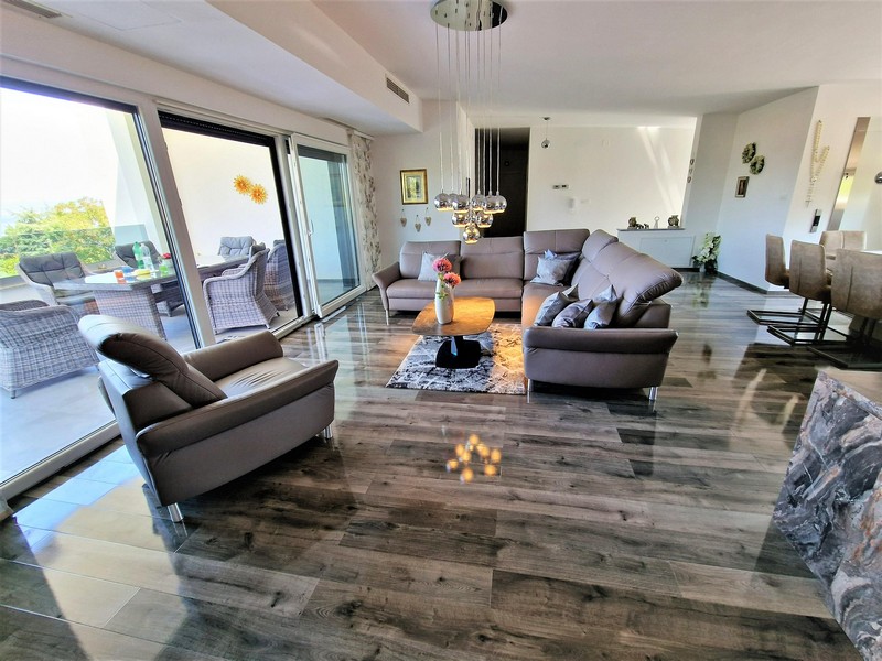 Vardagsrum med högkvalitativ inredning och utsikt över havet.