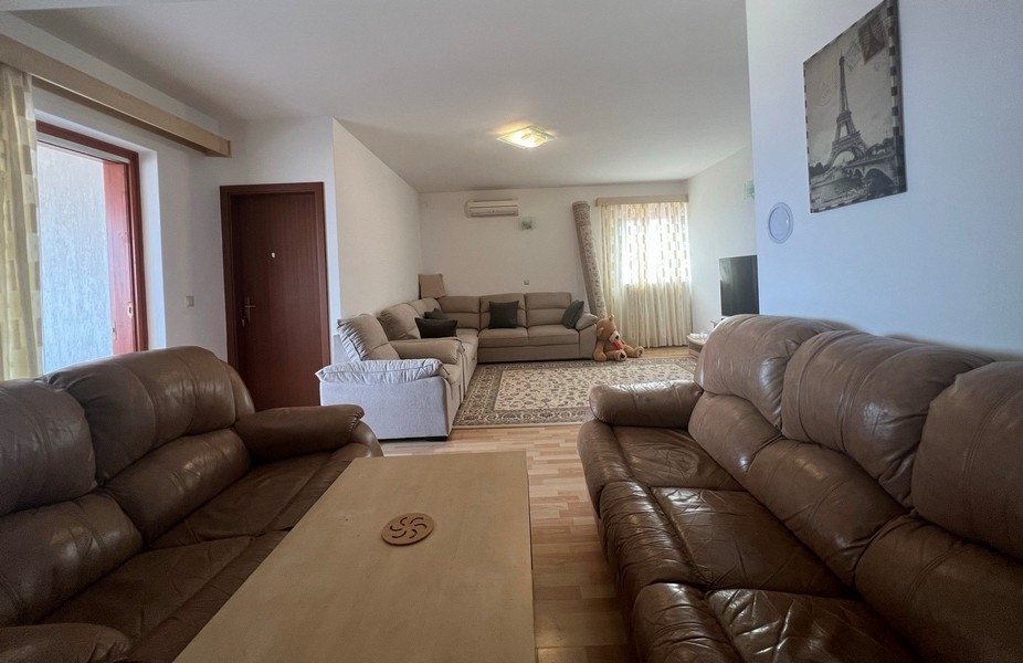 Vardagsrummet med tre soffor.