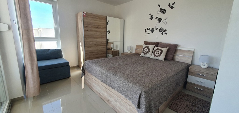 Sovrum med fönster och utgång till balkong