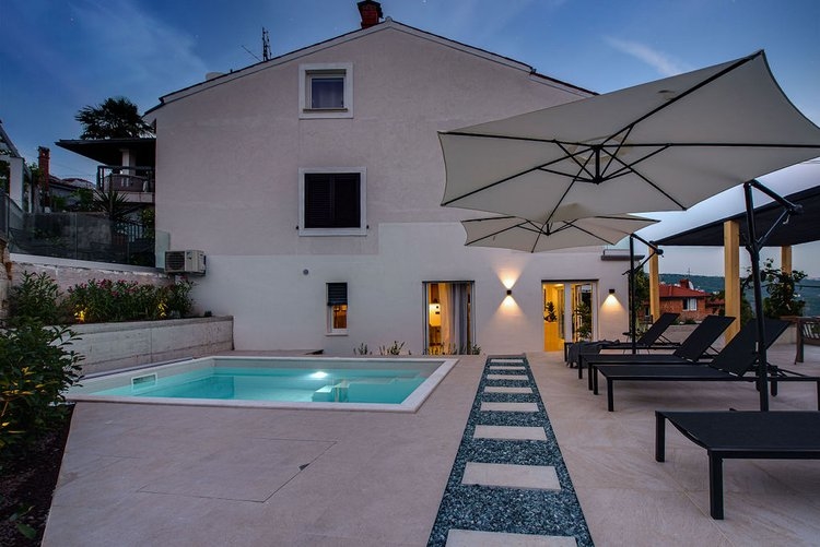 Privat trädgård med vacker, upplyst pool av lägenhet A3007, som är till salu i Opatija, Kroatien.