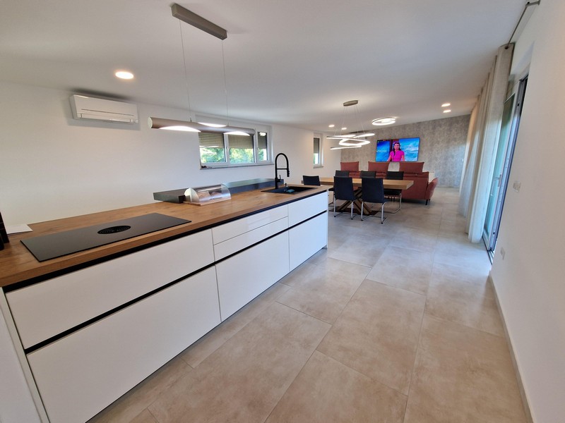 Modernt kök och det rymliga vardagsrummet i fastighet A3043, Kroatien, ön Krk.