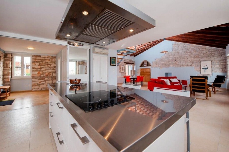 Högkvalitativ köksö med spis och utsikt in i medelhavets vardagsrum.