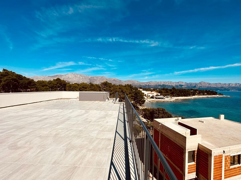Takterrass med utsikt över havet och bergen.