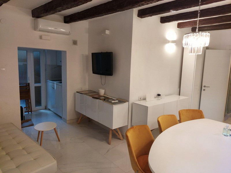 Luftkonditionerat vardagsrum med TV och matplats samt ett pentry.