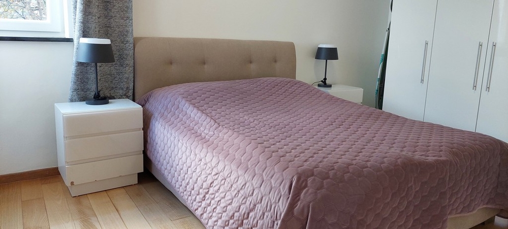 Sovrum med stor dubbelsäng och minimalistisk design i Opatija