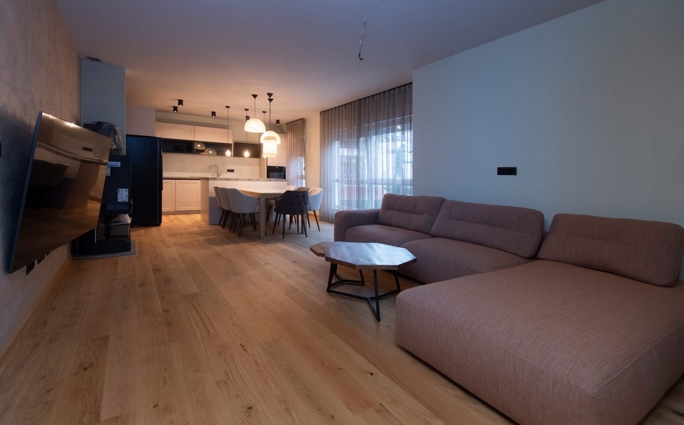 Rymligt och ljust vardagsrum i en modern lägenhet i Split, Kroatien, med parkettgolv och chic inredning.