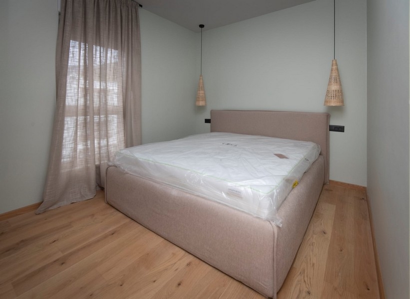 Enkelt mästerverk sovrum i en modern lägenhet i Split, Kroatien, med minimalistisk design och neutrala toner.