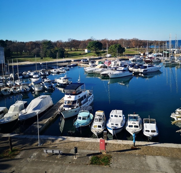Marina i Kroatien med en mängd olika båtar och yachter under en klarblå himmel - köp en lägenhet med havsutsikt i Kroatien. Panoramaspaning