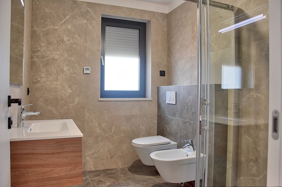 Elegant badrum i en takvåning till salu i Istrien, med modern inredning och marmorkakel.