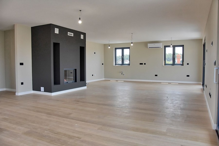 Modernt vardagsrum i en takvåning till salu i Istrien, med öppen spis och havsutsikt.