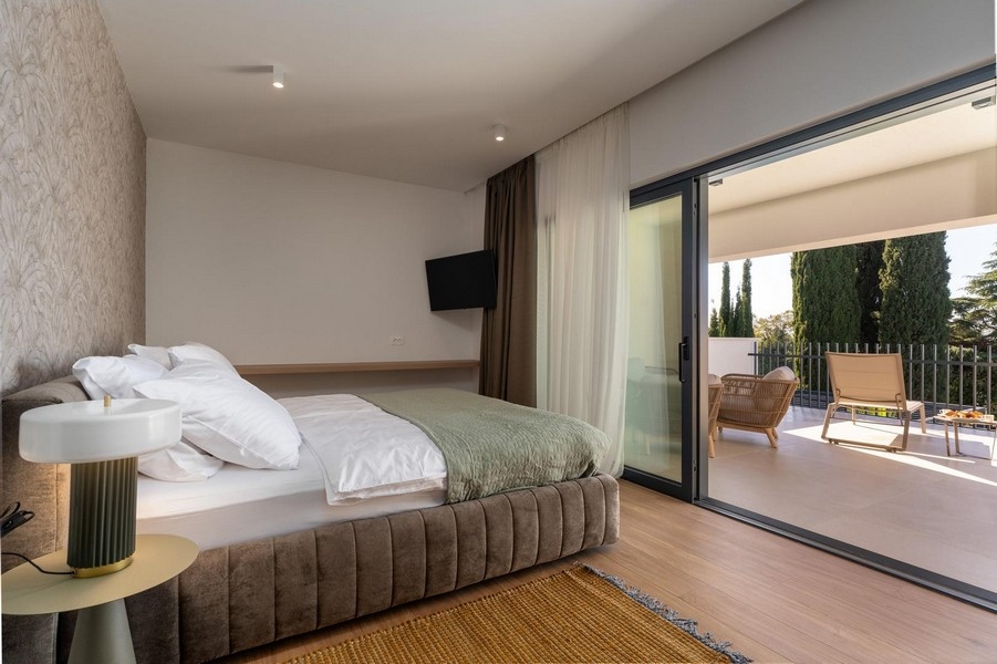 Sovrum med generösa glasrutor och tillgång till terrass i en lyxig lägenhet i Istrien