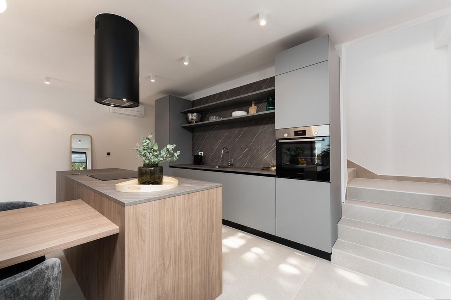 Modernt kök med central kokö och högkvalitativa inbyggda apparater i lyxlägenhet i Istrien