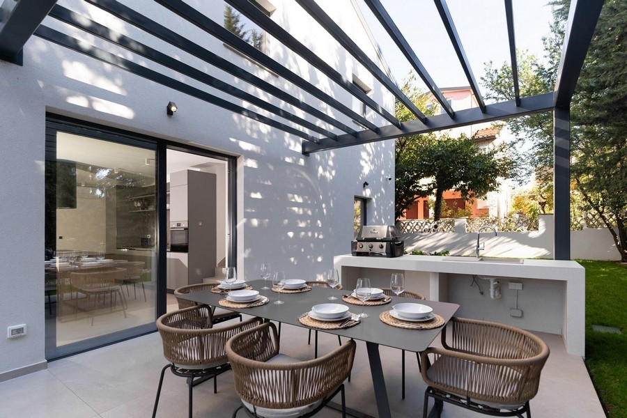 Täckt terrass i en lyxig lägenhet i Istrien med sommarkök och matplats utomhus