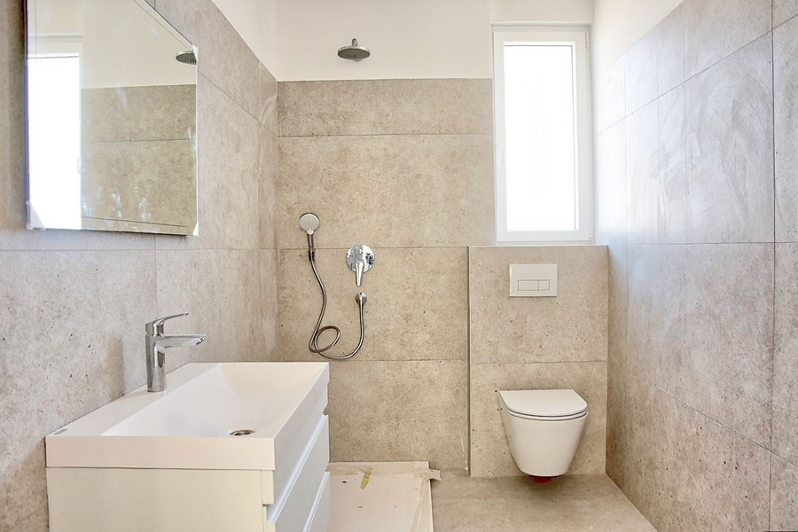 Stilrent badrum med modern inredning och fin stenbeklädnad i en lyxig lägenhet i Istrien