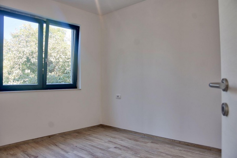 Andra sovrummet med fönsterutsikt över grönområden, en del av fastighetserbjudandet i Porec