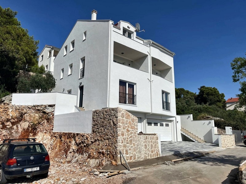 Exteriör vy av fastigheten, modern fasad med garage och trappa