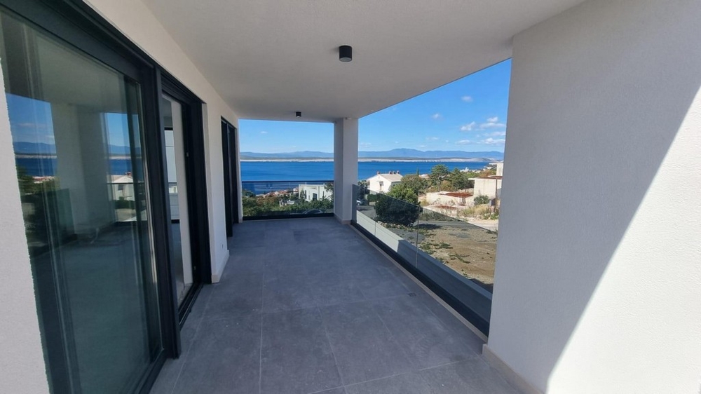 Täckt terrass i en modern lägenhet i Kroatien med utsikt över havet och det omgivande området.