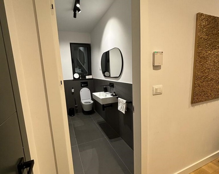 Modernt badrum med grått kakel och speglar, fastighet till salu i Rijeka, Kroatien.