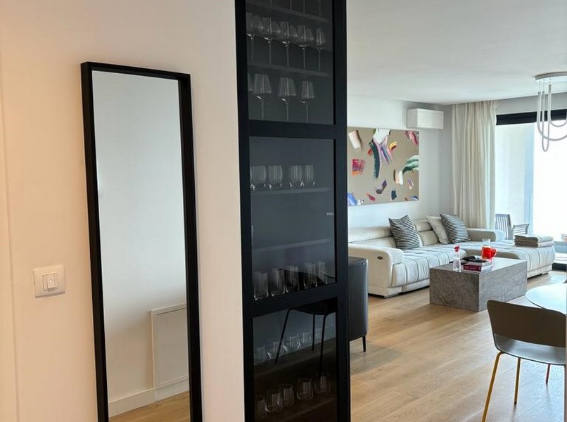 Elegant vinställ bredvid en svart glasdörr, detalj av en lägenhet till salu i Rijeka, Kroatien.