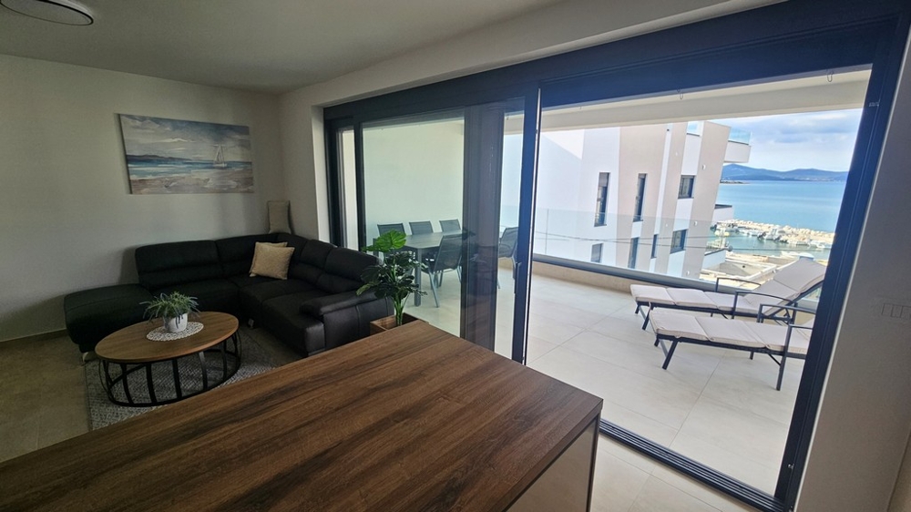 Modernt kök med barstolar i en takvåning till salu i Zadar, Kroatien, med utsikt utanför