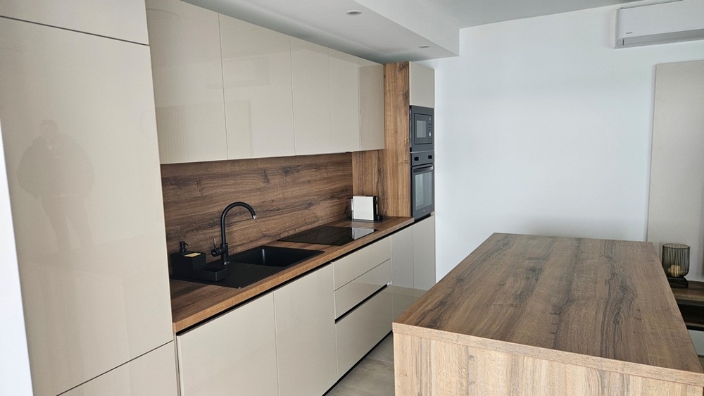 Öppen planlösning med kök och matplats med havsutsikt i en takvåning till salu i Zadar, Kroatien