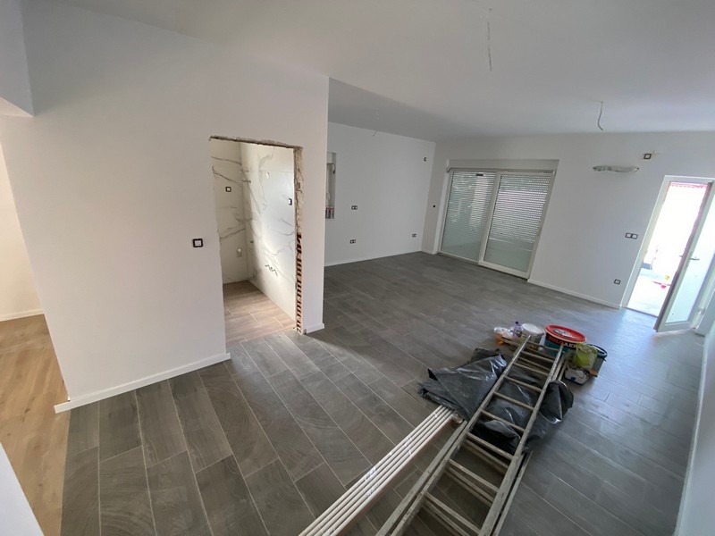 Tomt vardagsrum med grått klinkergolv i lägenhet till salu i Pag, Kroatien