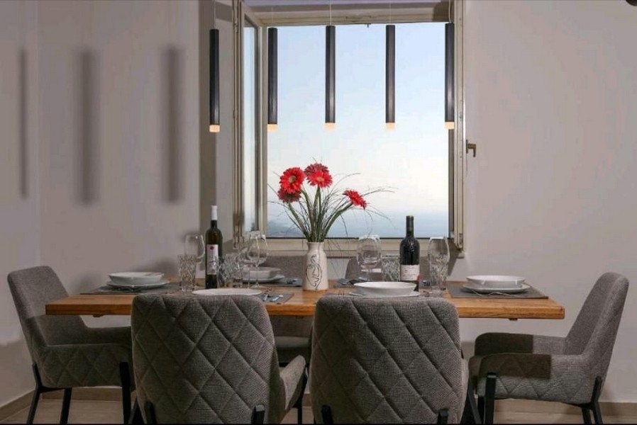 Matsal med bord och stolar i lägenhet med havsutsikt genom fönstret, till salu nära Opatija, Kroatien