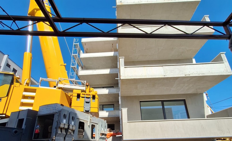Kranarbete på den nya byggnaden av ett hyreshus med utsikt över den omgivande arkitekturen i Kroatien, som erbjuds av Panorama Scouting