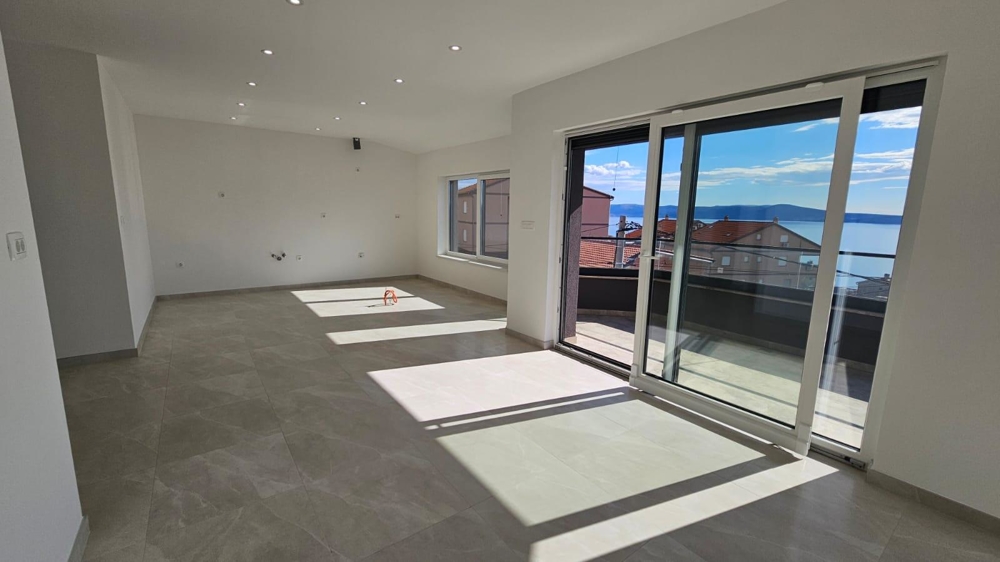 Solbelyst vardagsrum i försäljningslägenheten i Crikvenica med tillgång till balkong och utsikt över kusten