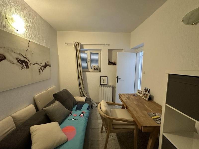 Mysigt vardagsrum med soffa och matplats, lägenhet i Tisno, Kroatien till salu