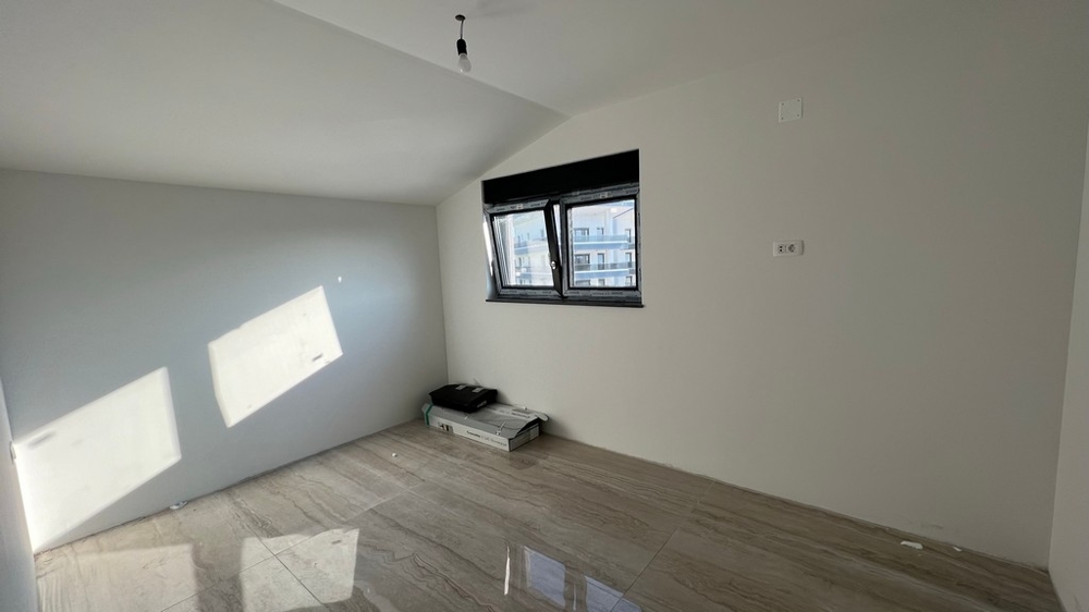 Minimalistiskt utformat vardagsrum med ljusa klinkergolv, lämpligt för moderna fastigheter i Kroatien.