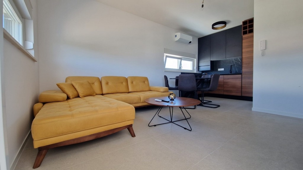 Interiör av en lägenhet i Novalja, Pag Island, med moderna möbler och gul soffa, Kroatien fastigheter