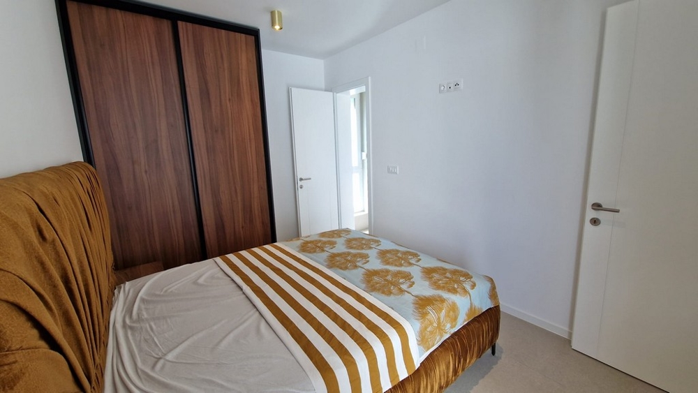 Sovrum i en lägenhet i Novalja, ön Pag, med randigt sänglinne och träelement, Kroatiens fastigheter