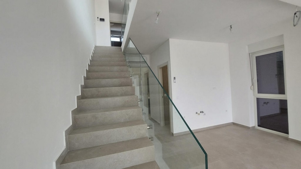 Korridor med vitmålade väggar, luftkonditionering och dörrar till övriga rum