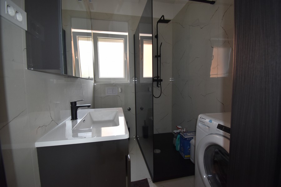 Modernt badrum med duschkabin och tvättmaskin, en del av Real Estate Kroatien