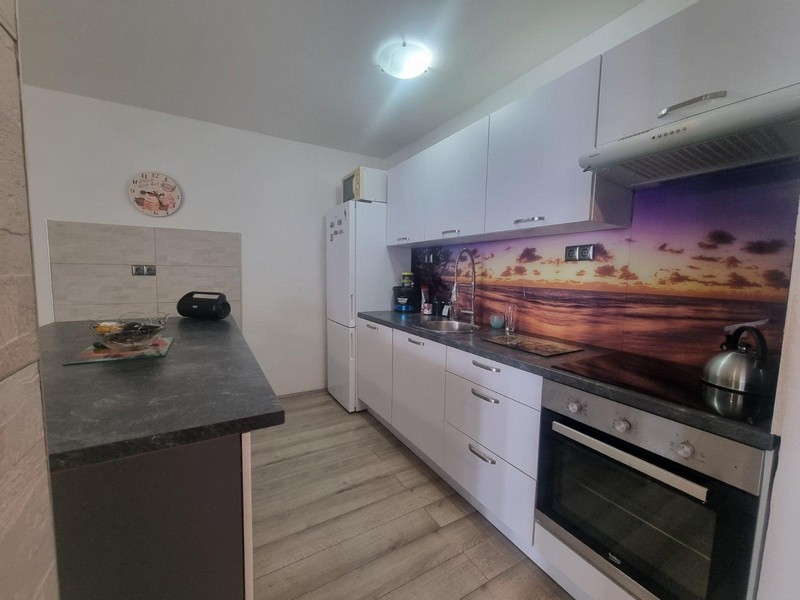 Modernt kök med strandmotiv på bakväggen