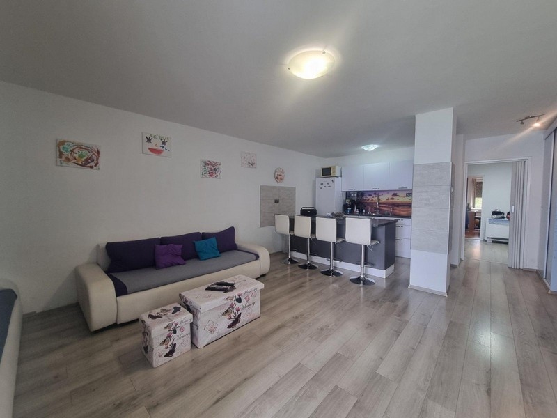 Öppen vardagsrumsdel med modern inredning och pentry i bakgrunden