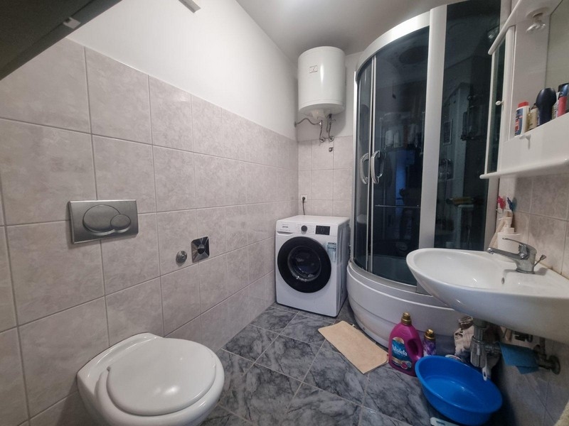 Badrum med dusch, tvättmaskin och toalett