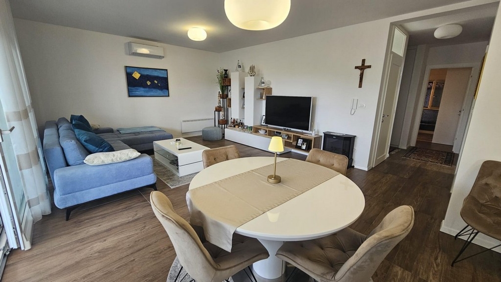 Högkvalitativt vardagsrum med luftkonditionering, en blå soffa och en modern smart-TV.