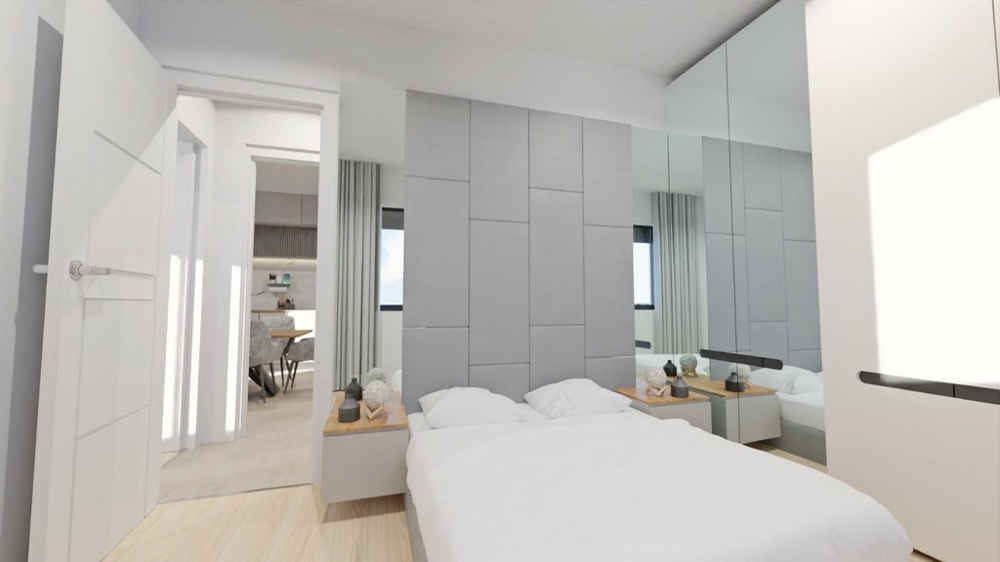 Ljust sovrum med speglar, vita möbler och tillgång till vardagsrummen.
