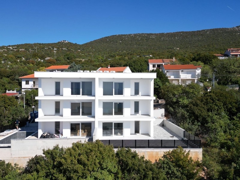 Flygfoto över ett modernt hyreshus i Smokvica Krmpotska med pool och anlagd trädgård