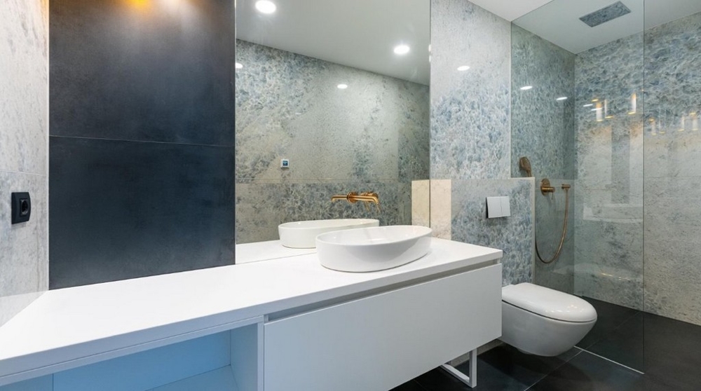 Modernt badrum med vitt handfat, glasdusch