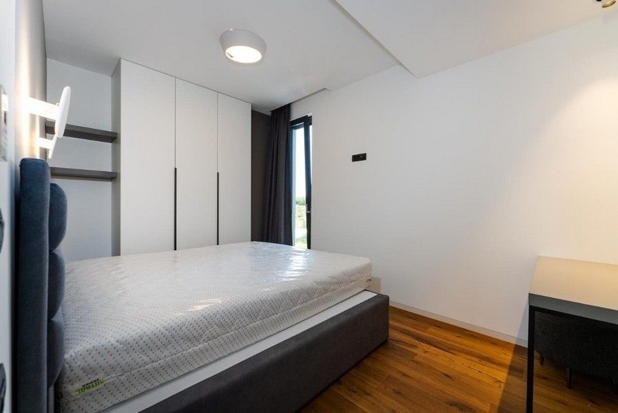 Rymligt sovrum med stort fönster och inbyggda garderober